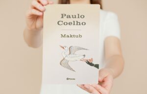 Una mujer muestra la portada del libro Maktub, un libro de Paulo Coelho