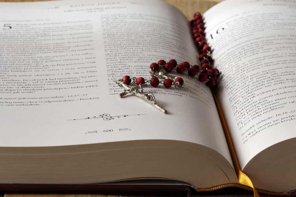 Ejemplar de una Biblia abierta con un rosario sobre sus páginas.