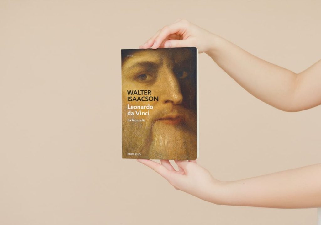 Una persona sostiene con sus manos un ejemplar del libro Leonardo da Vinci: La biografía, de Walter Isaacson