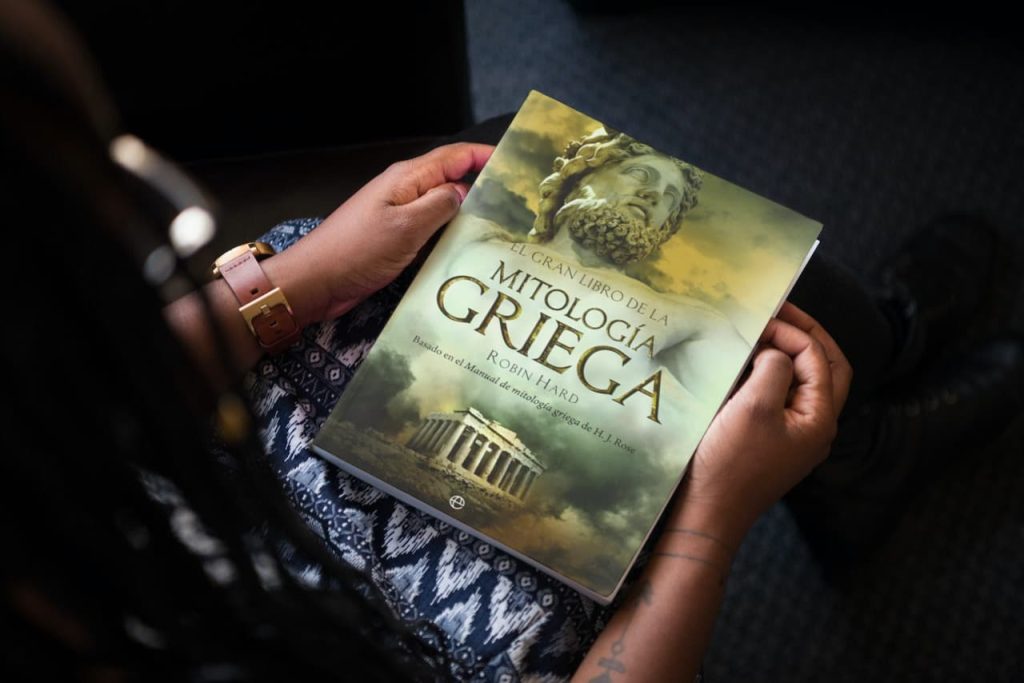 Persona sosteniendo 'El Gran Libro de la Mitología Griega' de Robin Hard