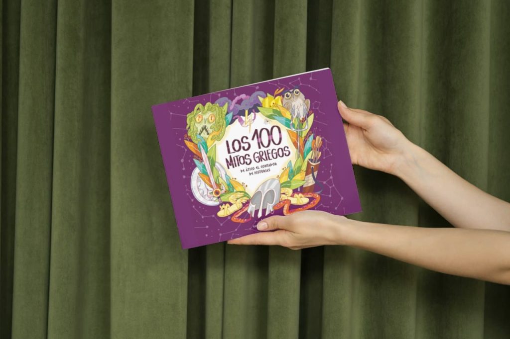 Manos sosteniendo el libro 'Los 100 mitos griegos de Ático el contador de historias' de Lucy Coats, con una portada colorida sobre un fondo de cortina verde