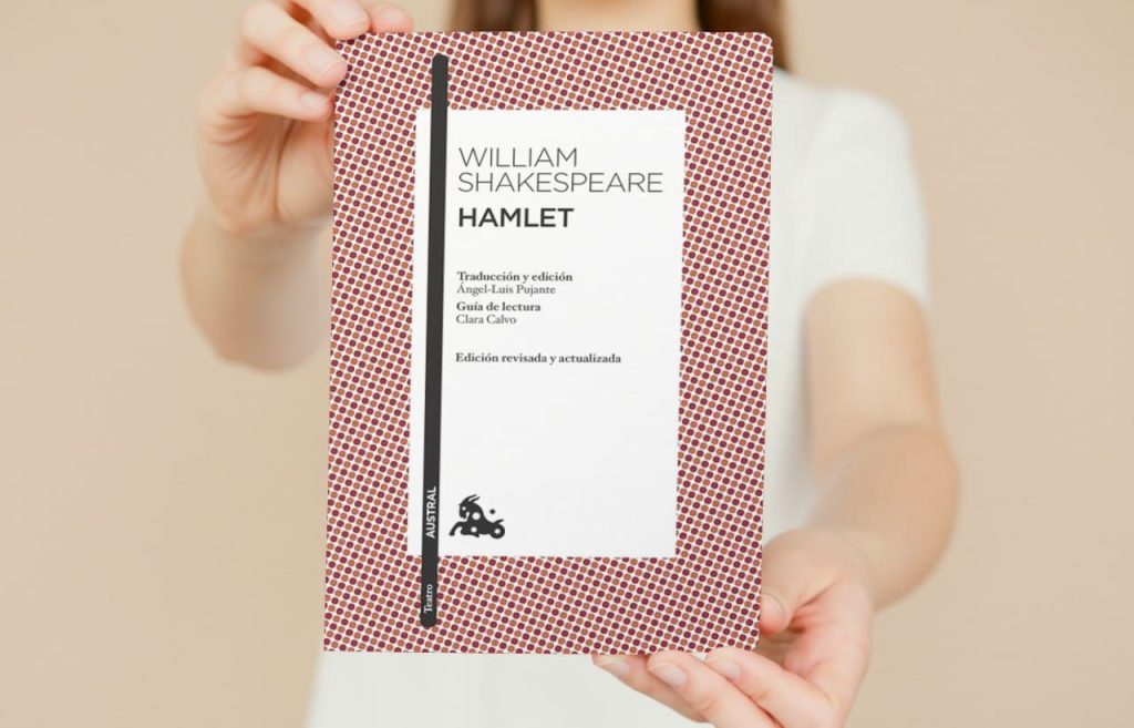 Persona sosteniendo una edición de 'Hamlet' de William Shakespeare con traducción y edición destacadas en la portada