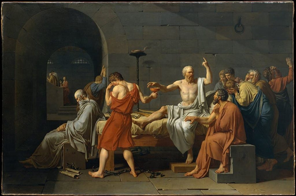 Pintura 'La muerte de Sócrates' de Jacques-Louis David, mostrando a Sócrates extendiendo su brazo con valentía mientras se prepara para beber la cicuta, con sus discípulos expresando angustia y tristeza a su alrededor en un entorno sombrío de la antigua Atenas.