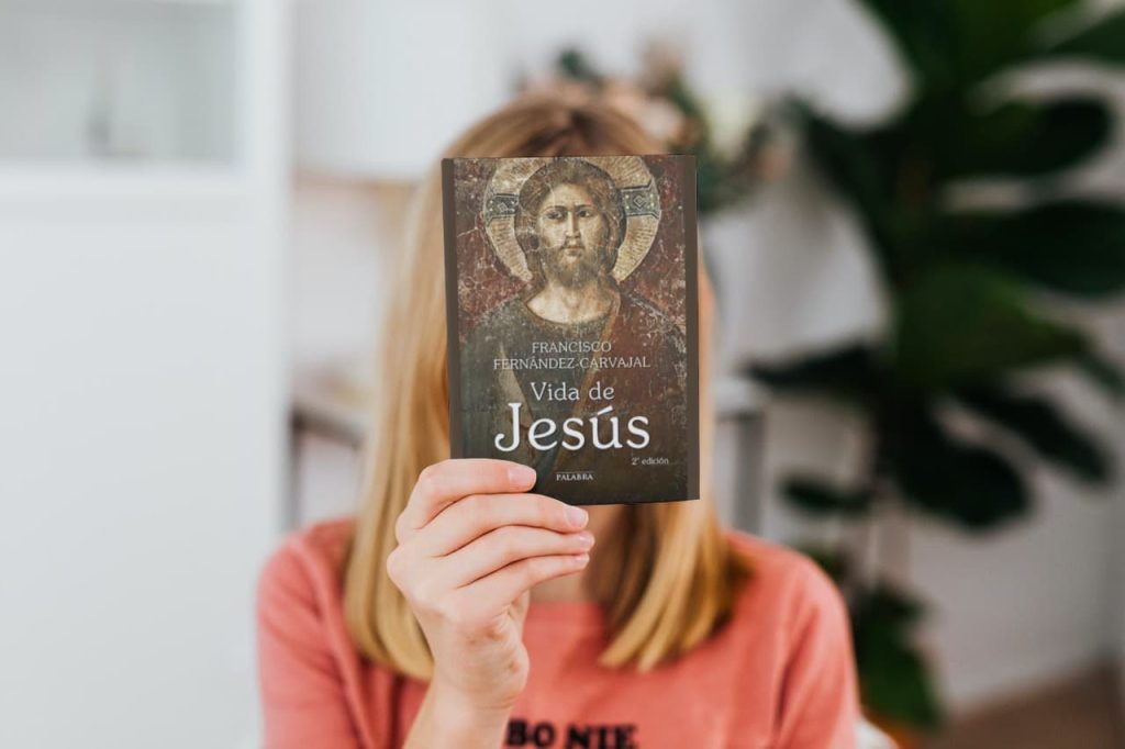 Una persona sostiene el libro 'Vida de Jesús' de Francisco Fernández-Carvajal frente a su rostro.